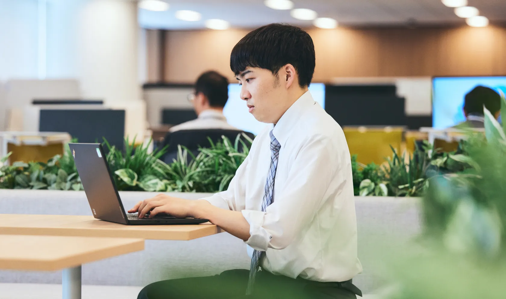 DXエンジニアがオフィスでシステム開発業務を行う様子